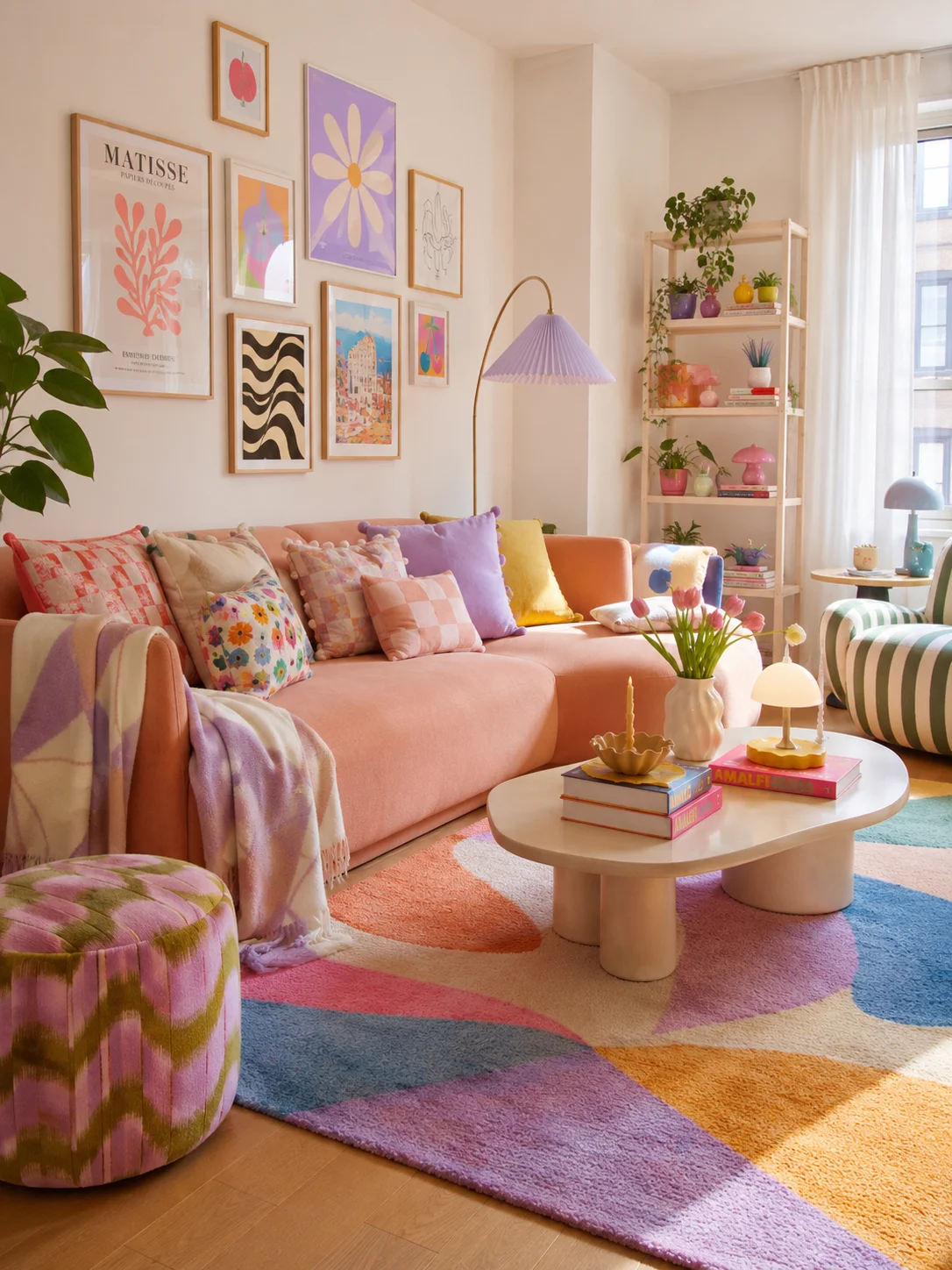 Colorful modern living room with a blush pink sofa, floral cushions, striped chair, bright art, and tulips